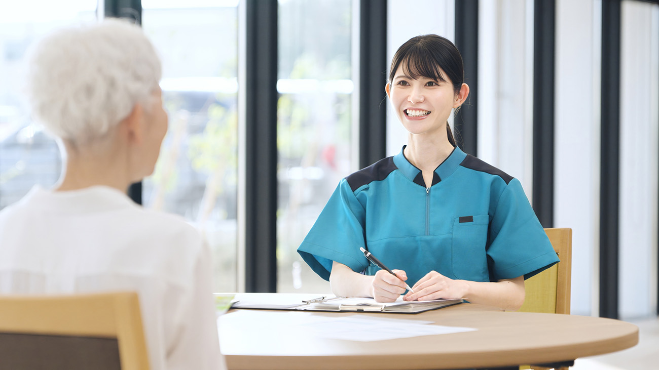 介護サービスについて相談する高齢者とスタッフ